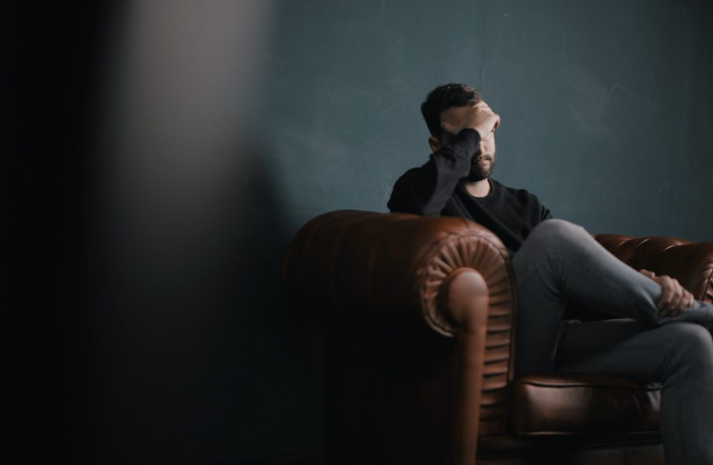 depressed man sitting on a couch
