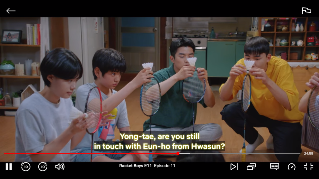 Screenshot from the Korean drama Racket Boys showing four young athletes trying to balance shuttlecocks on top of their rackets