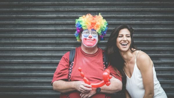 man dressed as a clown standing with a woman