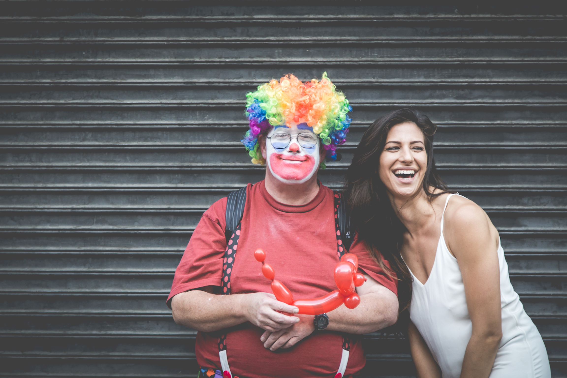 man dressed as a clown standing with a woman