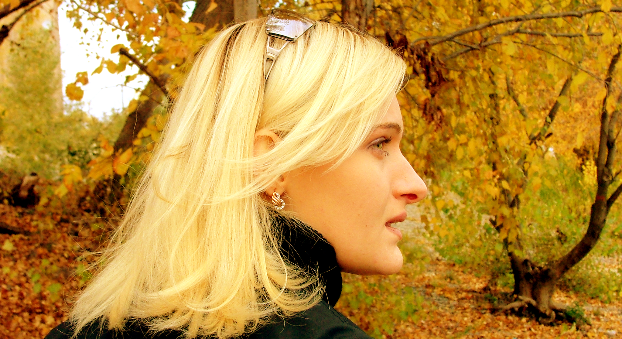 Blonde woman surrounded by autumnal trees