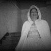 A lady, who is wearing a beautiful dress, is coming down the stairs.