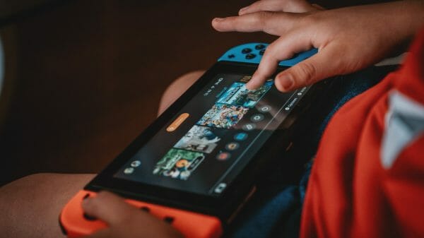 A child uses the touchscreen to select a game on a Nintendo Switch.