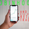 A hand holding a phone showing a chart of a stock - Robinhood and the rise of the retail investor