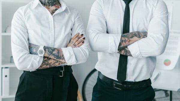 Tattooed man and woman wearing professional attire at work