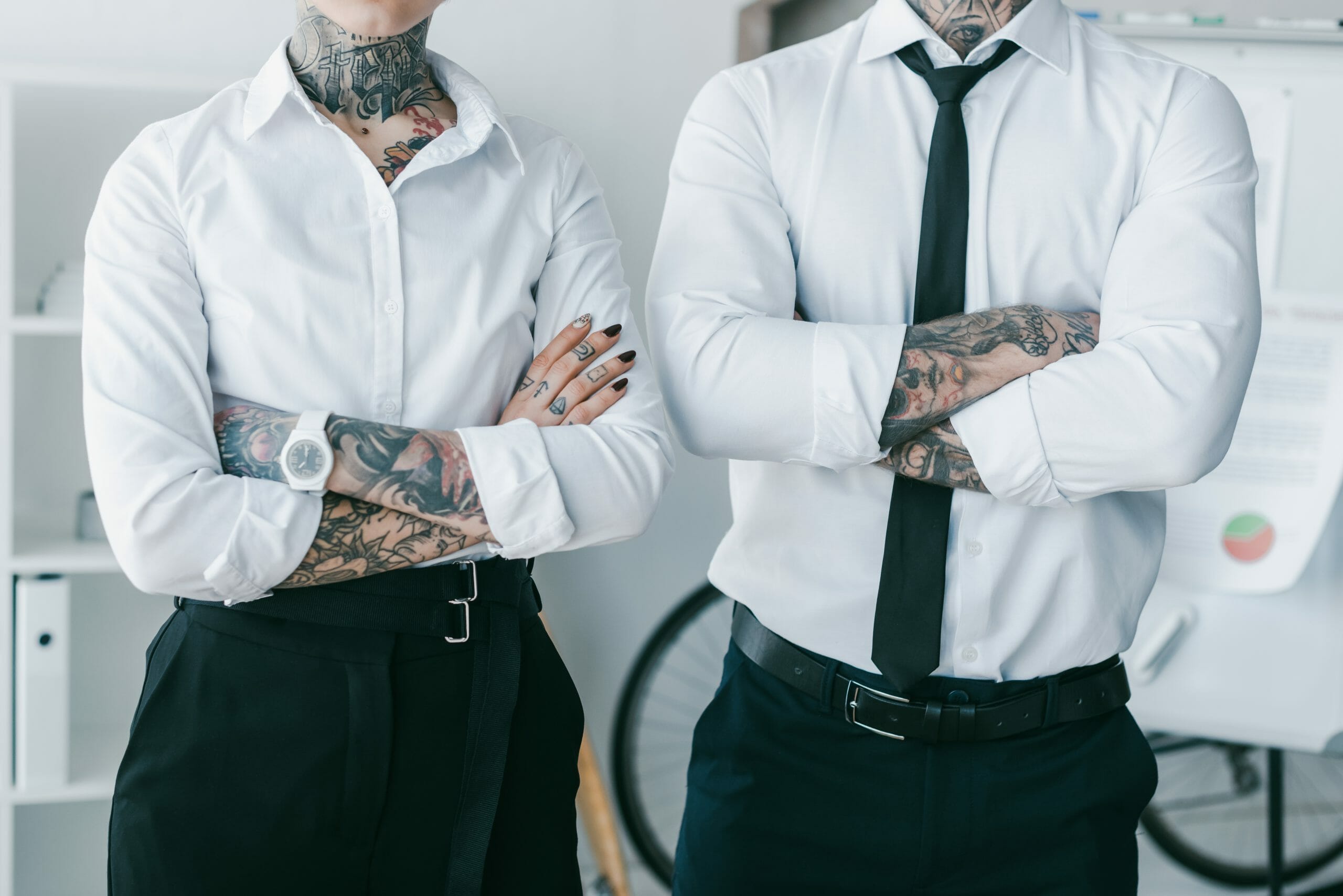 Tattooed man and woman wearing professional attire at work