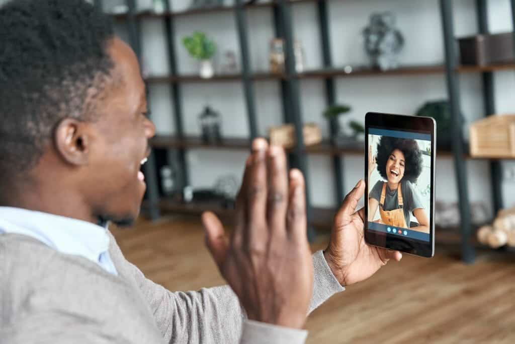 Black couple happily greeting each other on a video call