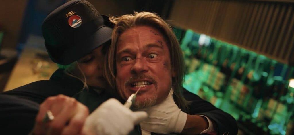Brad Pitt with a needle held to his mouth in bullet train.