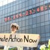 Protestor holding 'Climate Action Now' banner