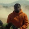 OJ (Daniel Kaluuya) rides a horse, with a cloud of dust in the background.