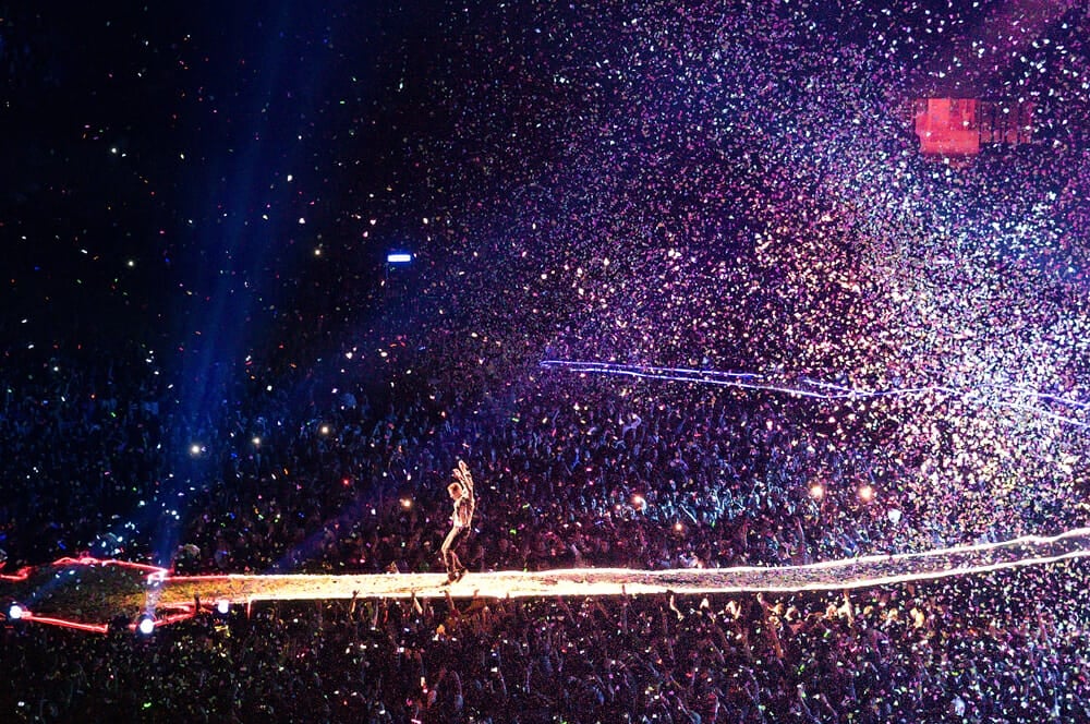 Chris Martin from Coldplay on stage with huge audience and confetti in Madrid