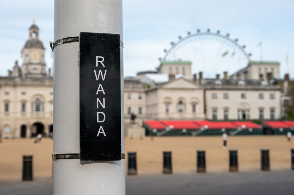 A close up of a sign saying 'Rwanda' for Jubilee Events with Horse Guards Parade and the London Eye in the background.