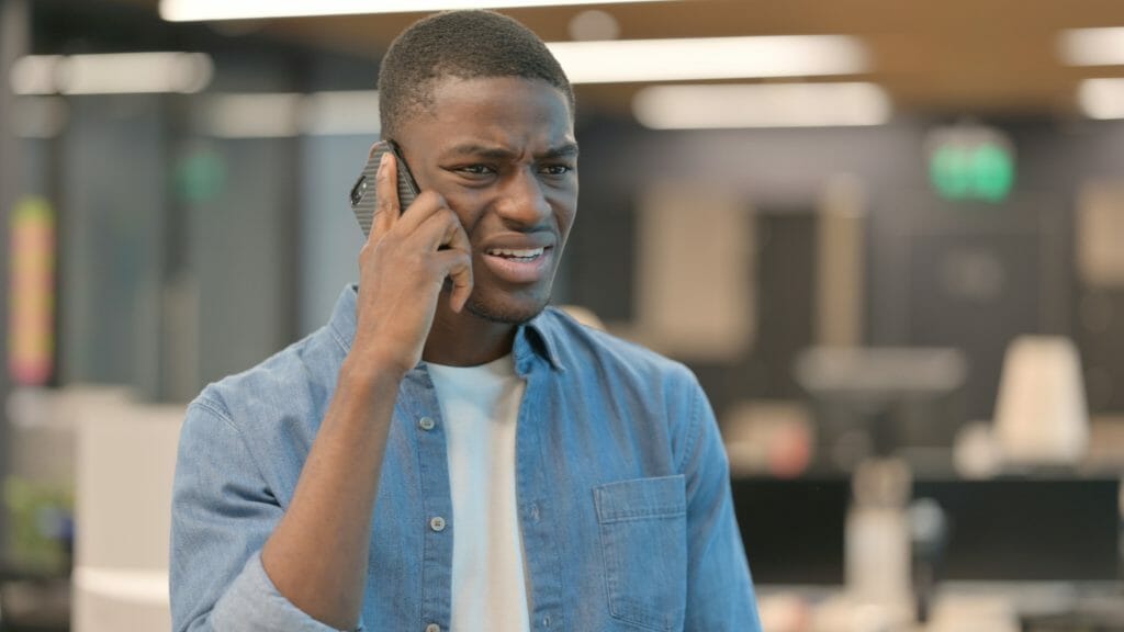 Black man looking upset on a phone call