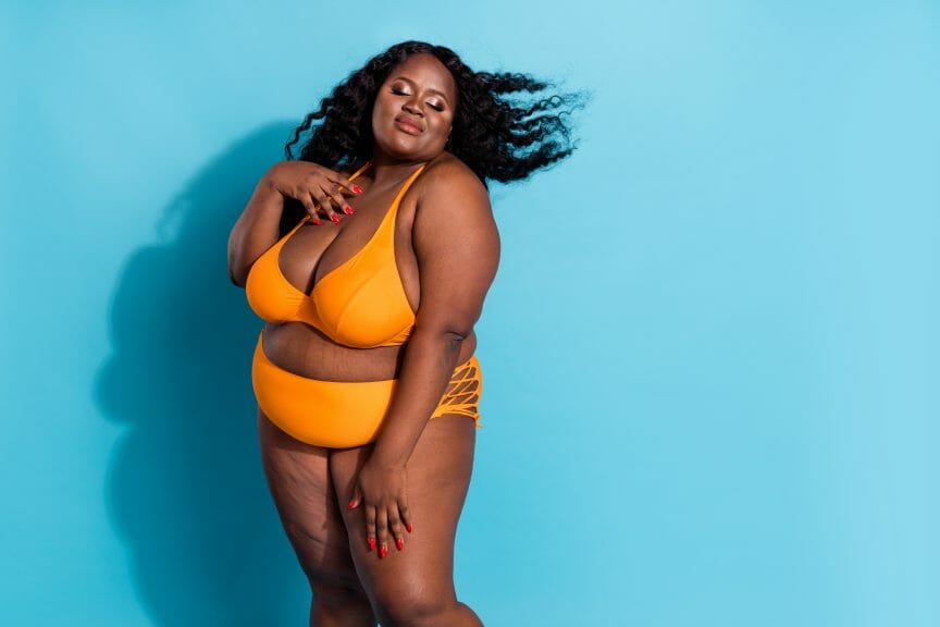 Plus size Black woman in yellow undergarments looking confident and radiant