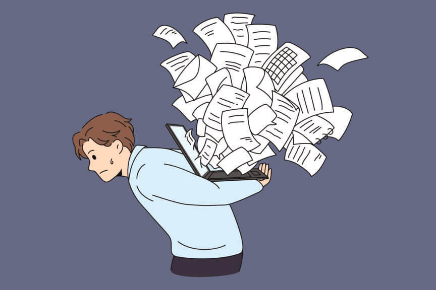 Cartoon of man carrying laptop with overflowing documents on his back