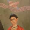 Painting of Frida Kahlo with a bird and banner