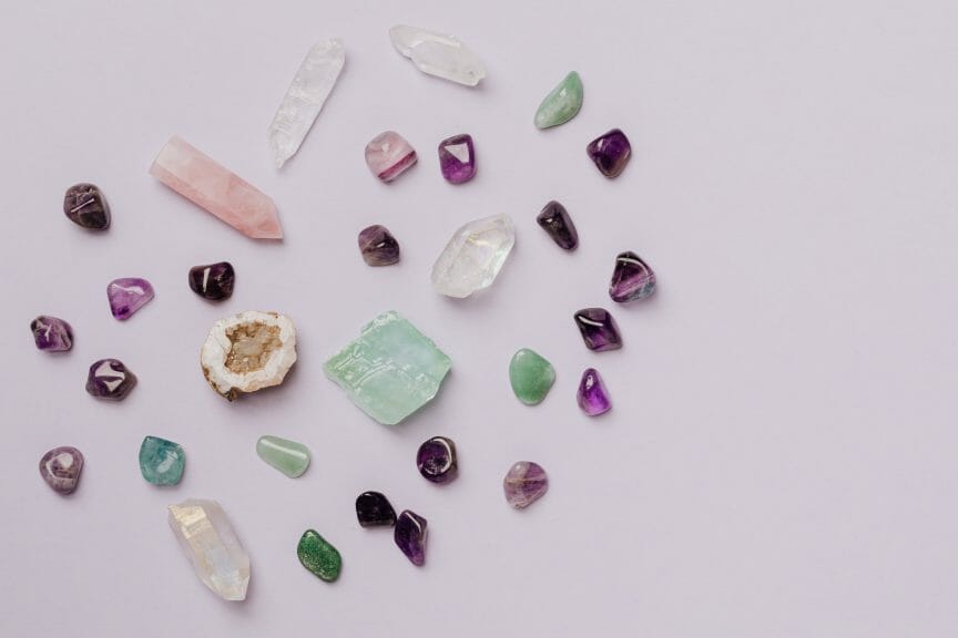 Small crystals of different colours against a pale purple background