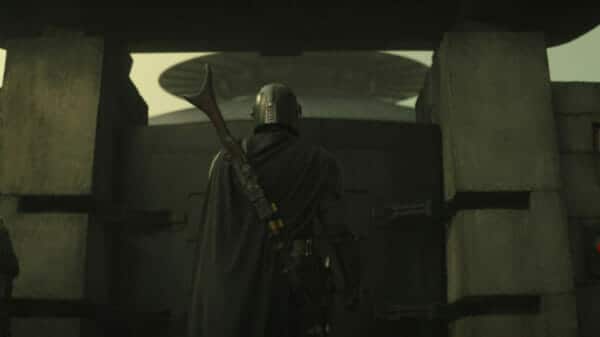 The Mandalorian (Pedro Pascal) stands with his back to the camera