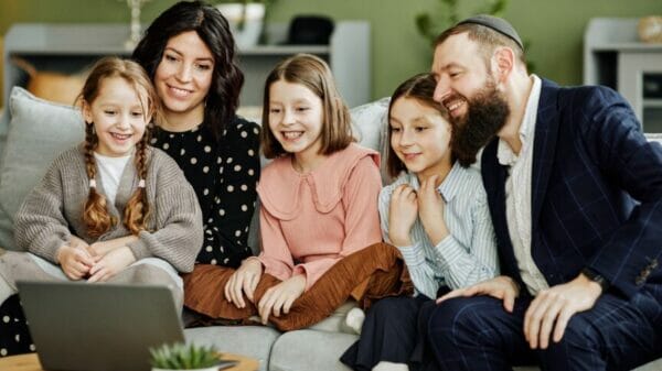 Jewish family watching a video on laptop.