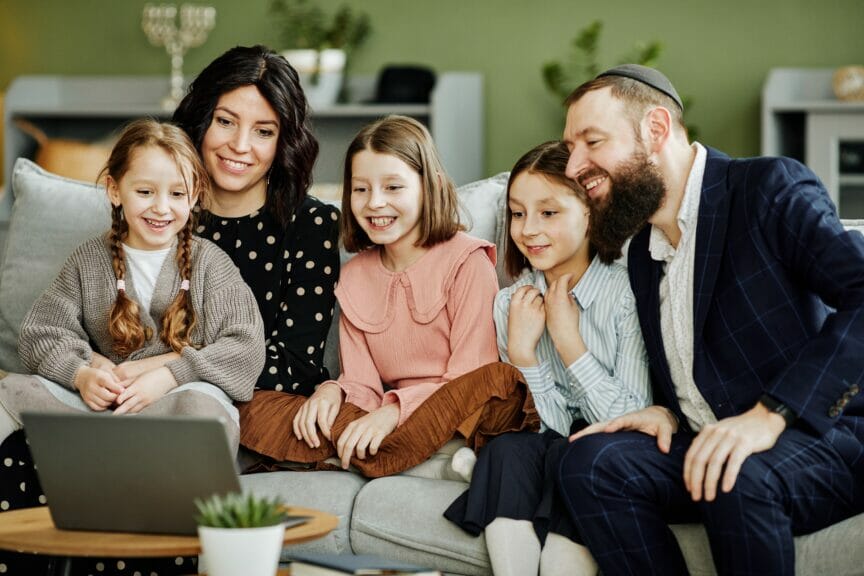 Jewish family watching a video on laptop.
