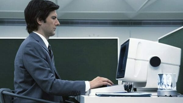 Mark (Adam Scott) types at his computer in a sterile office.