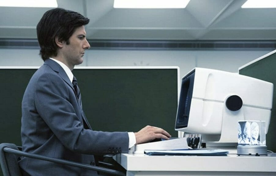 Mark (Adam Scott) types at his computer in a sterile office.