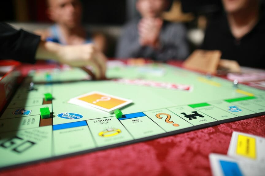 College students playing a game of monopoly, up-close shot of the board