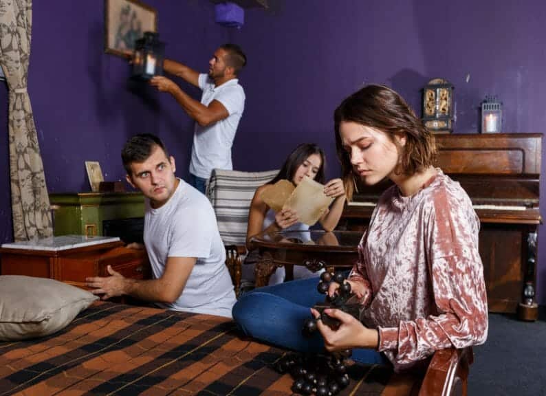 College students looking around at clues while participating in an escape room 