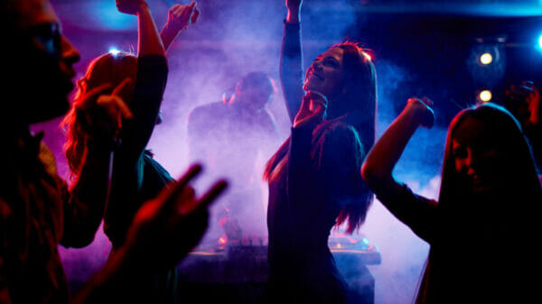 College students dancing together and having fun in night club