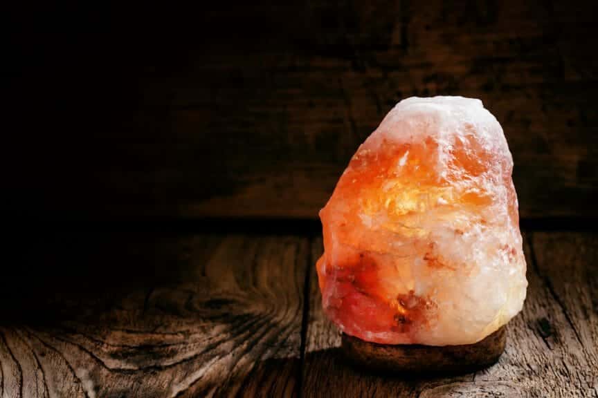 Himalayan salt lamp on wooden table.