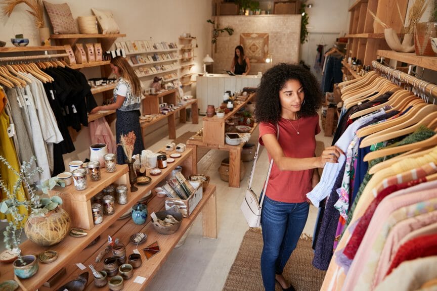 People thrifting and browsing shelves in a thrift store.