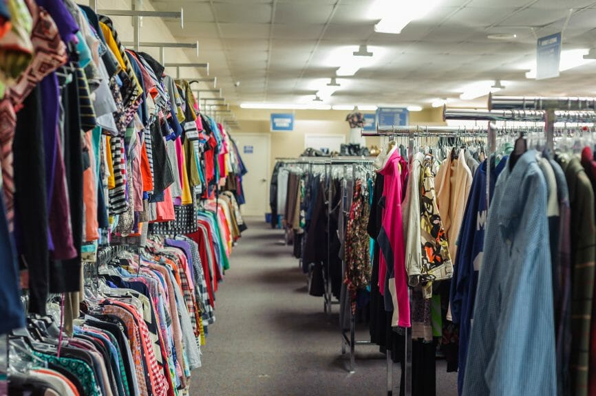 Lines of clothing racks for browsing for vintage items in a thrift store.