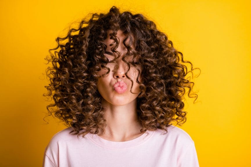 Woman with brown curly hair.