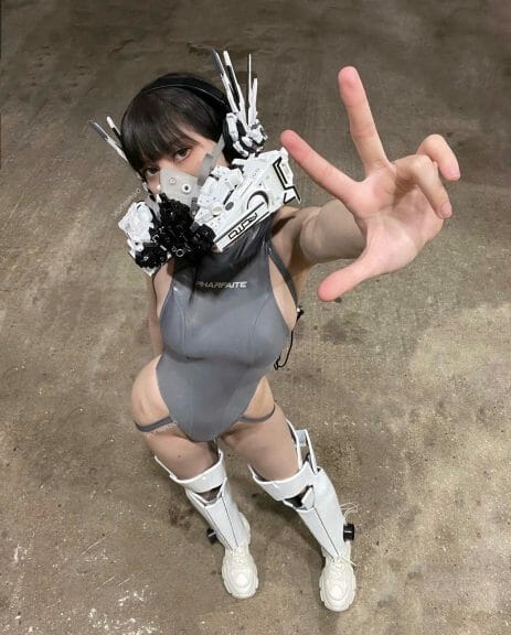 Yūn Mago wearing mecha headphones, mecha inspired face mask, and sculpted leg gear.
