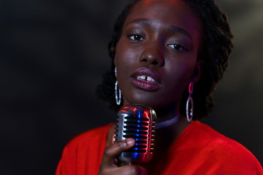 Woman R&B Singer holding microphone and looking at camera