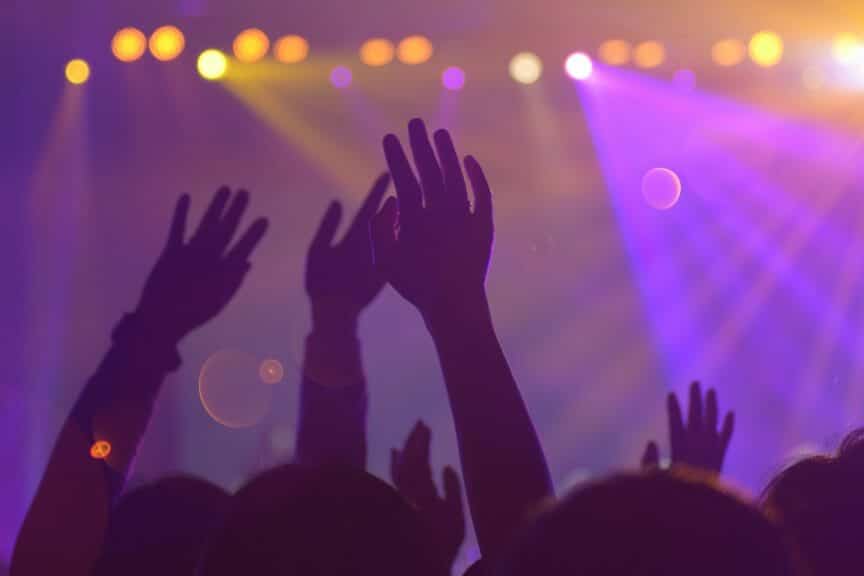 People at a concert with hands in the air.