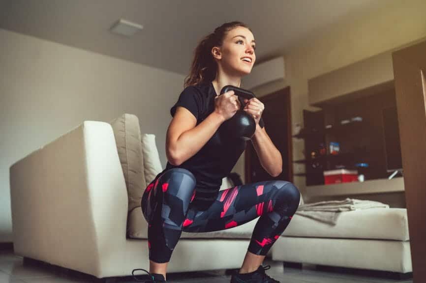 Woman squatting with weight in her hands.