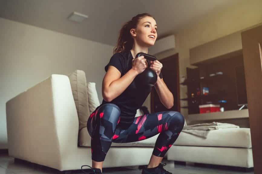 Woman squatting with weight in her hands. 