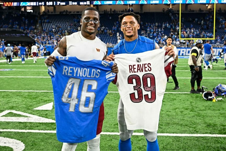 Two NFL players trading jerseys.