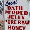 Image of a sign that reads local datil pepper jelly pure raw honey.