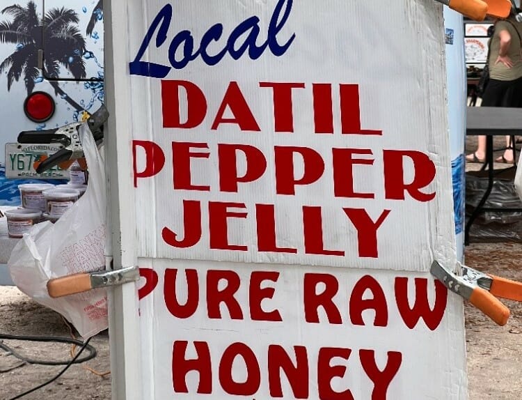 Image of a sign that reads local datil pepper jelly pure raw honey.