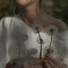 Woman in white dress holds flowers