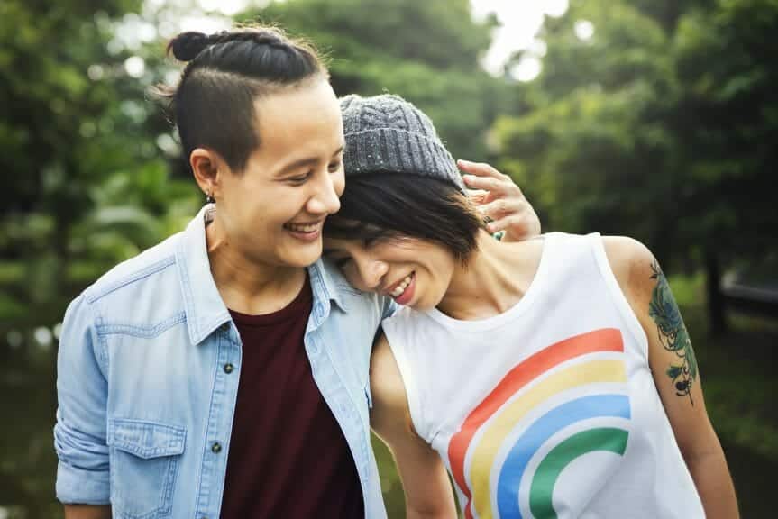 A lesbian couple hugging and smiling.