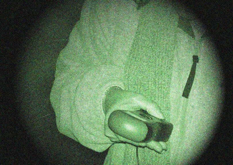 Person holding ghost hunting equipment in creepy and grainy photo.