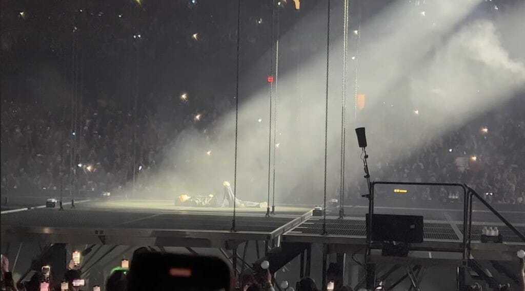 Agust D laying out on the stage at the beginning of his concert. 