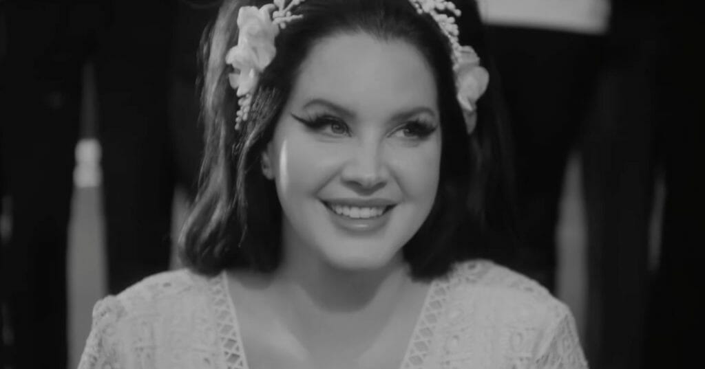 Lana Del Rey smiling at the end of "Candy Necklace."