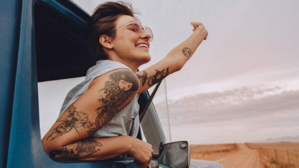 girl with western tattoos leaning out of car