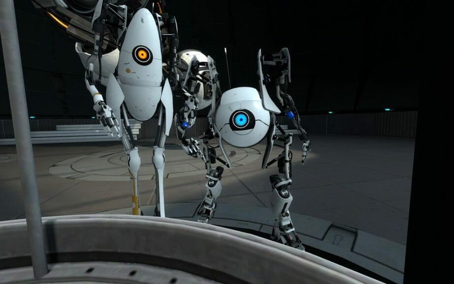 Two robots, one small, round, and blue, and the other tall, oval, and orange looking into camera in Portal 2 video game.