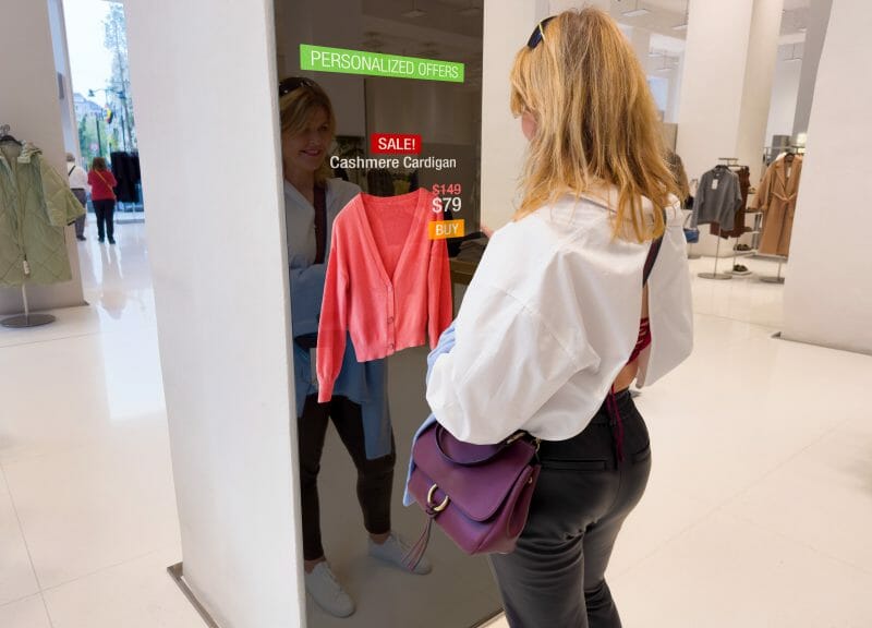 ShutterStock Kaspars Grinvalds: Woman viewing advanced mirror display in retail store showing personalized offers to customers