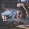 Woman looking exhausted at her desk.